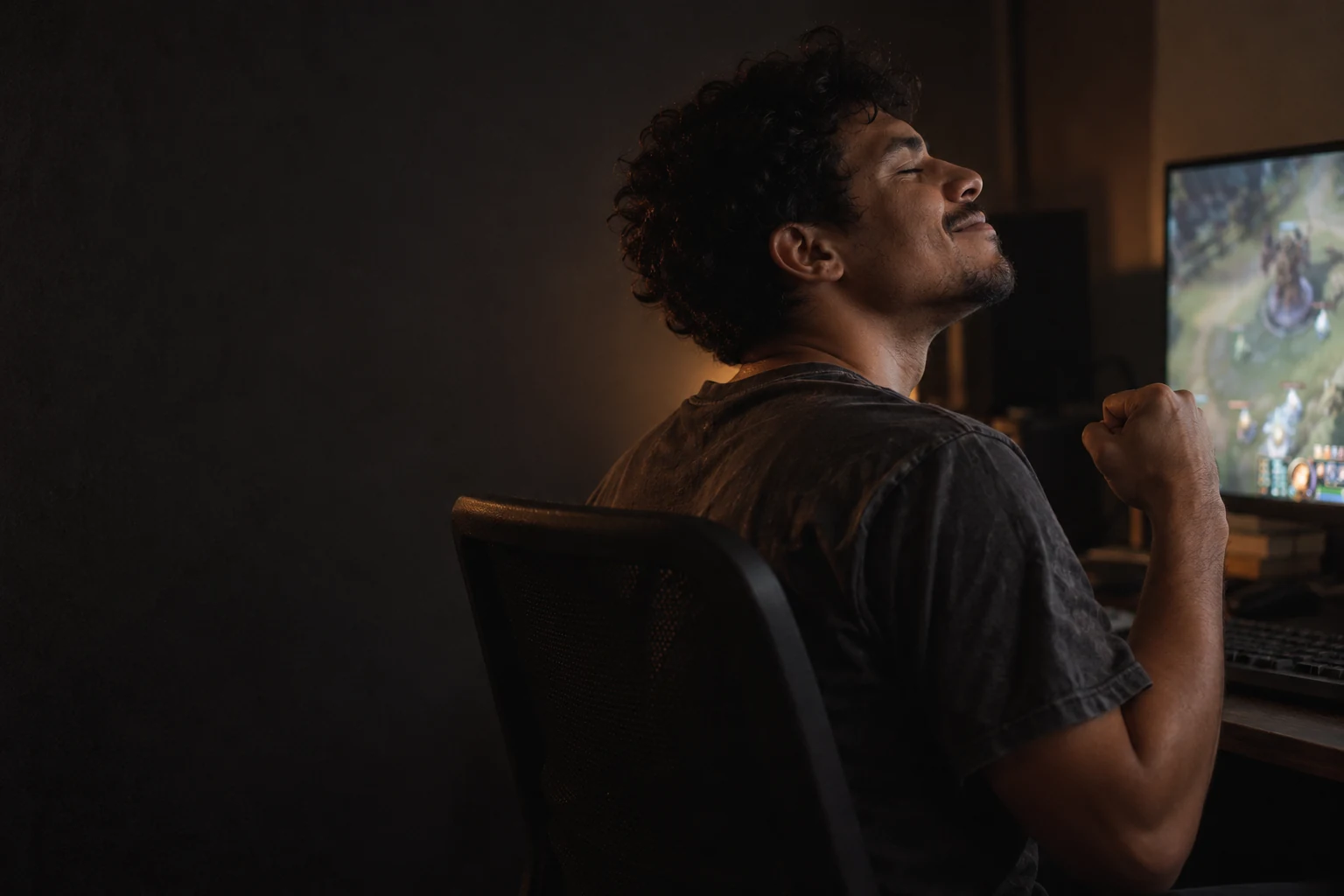 Jogador comemorando uma conquista no computador